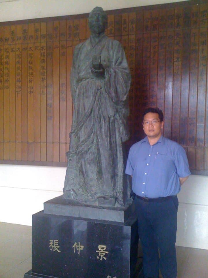 Dr. Philip Tan-Gatue beside a statue of Zhang Zhongjing at the Beijing University of Traditional Chinese Medicine